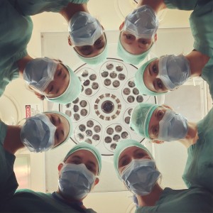 Medical professionals in face masks in a circle from below